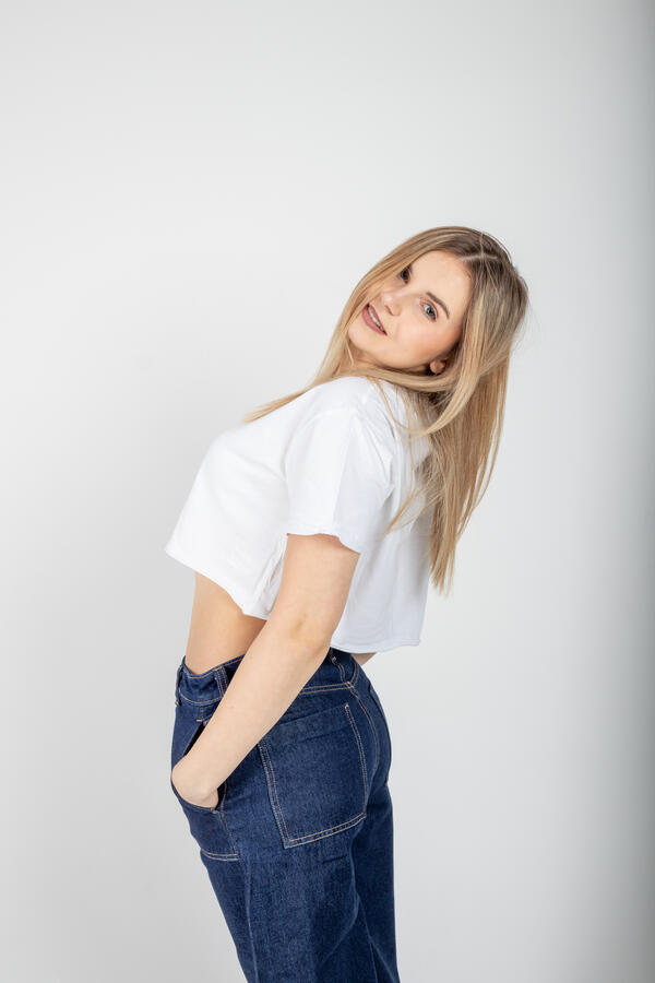 Portret Studio jeans Zdjęcie portretowe wykonane w studio na którym dziewczyna ubrana w biały T-shirt oraz jeansowe spodnie pozuje na stojąco