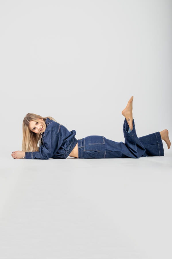 Portret Studio jeans Zdjęcie portretowe wykonane w studio na którym dziewczyna ubrana w jeansową kurtkę oraz jeansowe spodnie pozuje leżąc